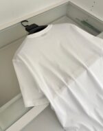 Maglietta bianca minimalista su appendiabiti nero, stile moderno e versatile per ogni occasione.
