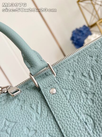 Borsa in pelle blu smeraldo, elegante, con dettagli embossati e hardware in argento di lusso.