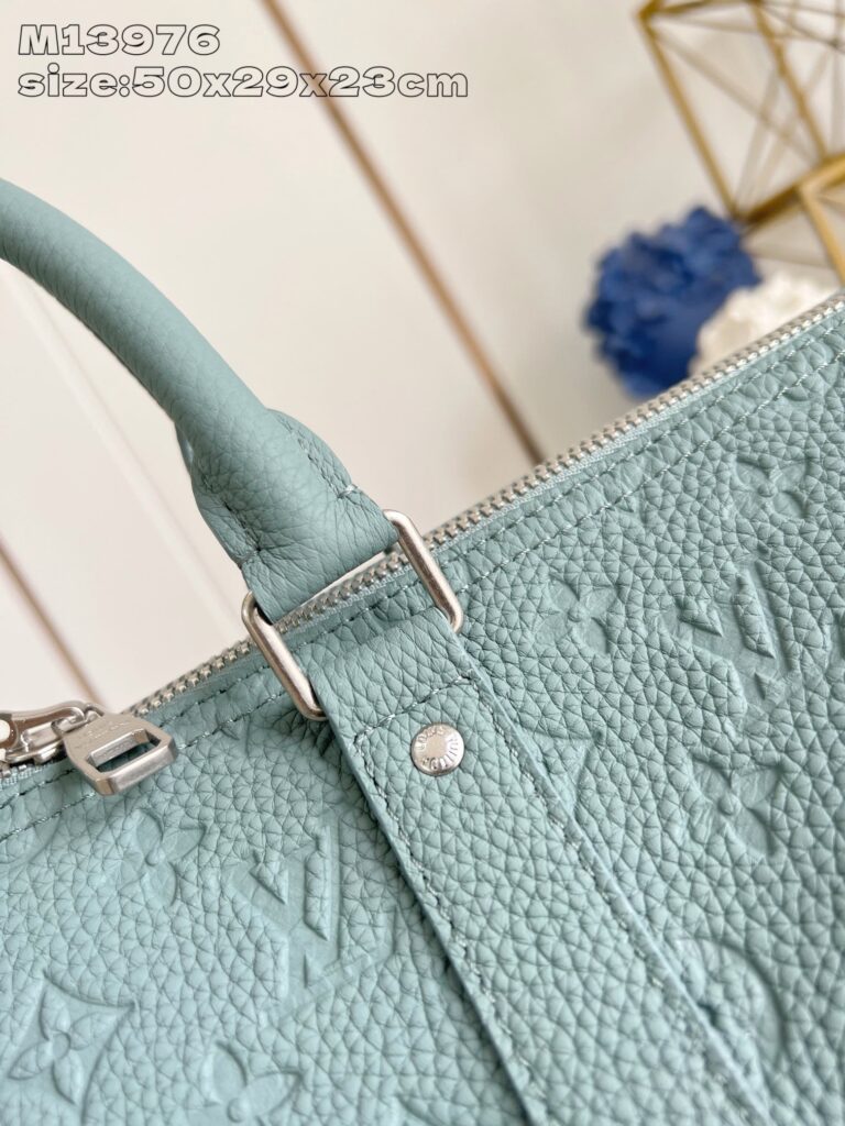 Borsa in pelle blu smeraldo, elegante, con dettagli embossati e hardware in argento di lusso.