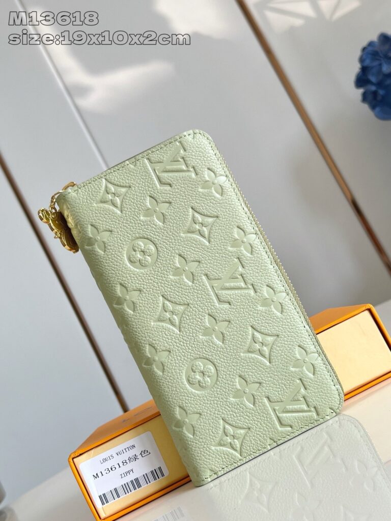 Portafoglio di lusso verde pastello con monogramma, elegante e compatto, con chiusura a zip.
