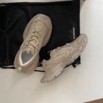 Sneakers beige moderni con borsa nera elegante, stile sportivo chic e dettagli di alta qualità.