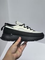 Sneaker bianca e nera moderna, comfort, supporto, design urban e stile contemporaneo.