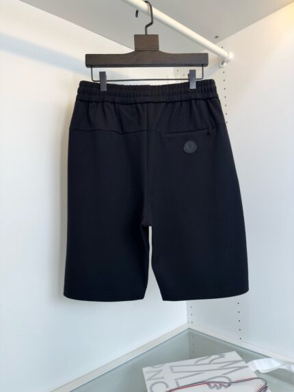 Shorts neri sportivi con elastico, logo minimal e taglio sopra il ginocchio.
