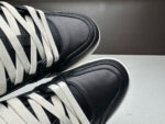 Sneakers nere in pelle lucida con lacci chiari e design moderno, eleganti e di tendenza.