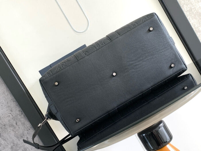 Bauletto nero elegante con borchie sottili e dettagli metallici su superficie moderna.