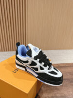 Scarpa sneakers nera e bianca con dettagli blu su scatola arancione, stile sportivo e moderno.