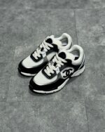 Sneaker moderne nero e bianco, stile urbano, suola antiscivolo e logo elegante.