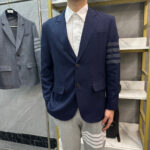 Look moderno con blazer sportivo, camicia elegante e pantaloni jogger con strisce.