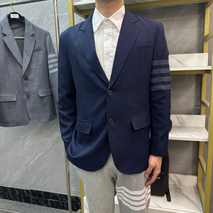 Look moderno con blazer sportivo, camicia elegante e pantaloni jogger con strisce.