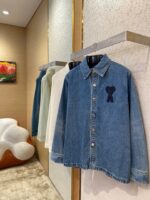 Display elegante di camicie uomo in denim, bianco e verde in boutique moderna.