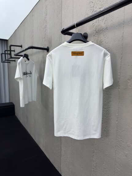 Esposizione di magliette bianche minimaliste su asta in stile industriale.