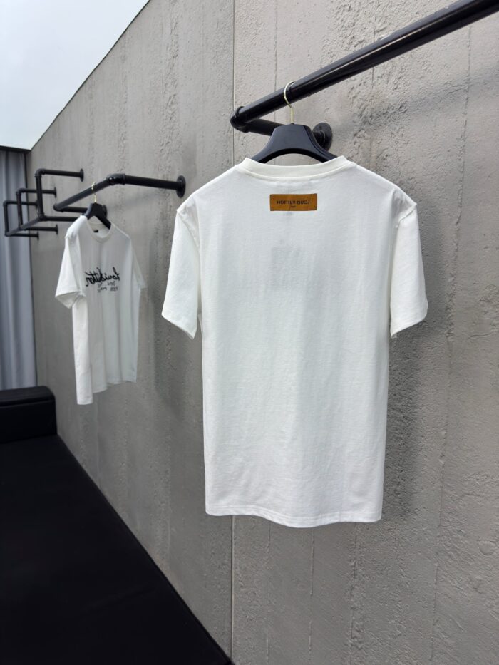 Esposizione di magliette bianche minimaliste su asta in stile industriale.