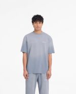 Uomo con outfit casual gradient e capelli ricci, stile moderno e confortevole.