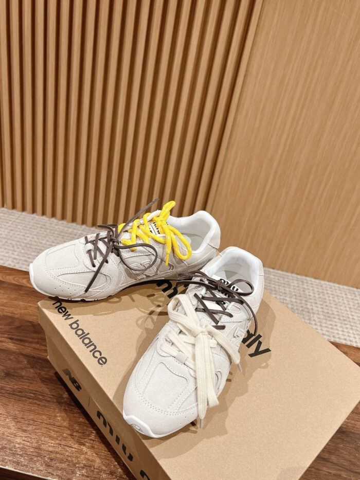 Sneaker New Balance con lacci colorati, stile moderno, su scatola in ambiente casalingo.