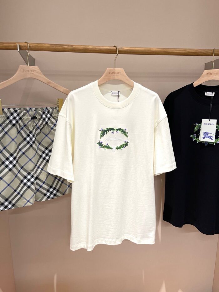 Display di abbigliamento casual con t-shirt grafica, shorts plaid e maglietta nera.