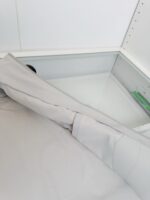 Cuscino morbido in tessuto grigio su tavolo in vetro per terapia e relax.