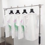 Magliette bianche con grafica a ragnatela verde in negozio streetwear moderno.