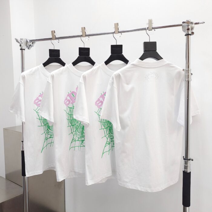 Magliette bianche con grafica a ragnatela verde in negozio streetwear moderno.