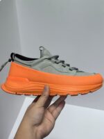 Sneaker moderna grigia e arancione, stile sporty e comfort per ogni occasione casuale.
