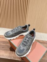 Scarpe sportive moderne grigie su superficie di legno con dettagli eleganti e suola robusta.