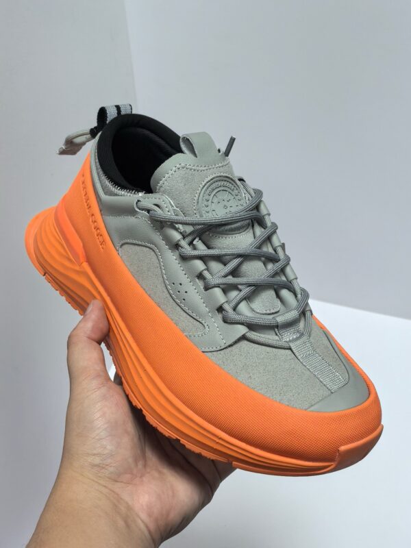 Scarpa sneaker moderna grigia e arancione, comfort e stile urbano, perfetta per outfit casual.