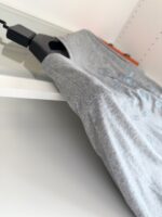 Camicia grigia moderna su appendiabiti nero, stile elegante e versatile per ogni look.