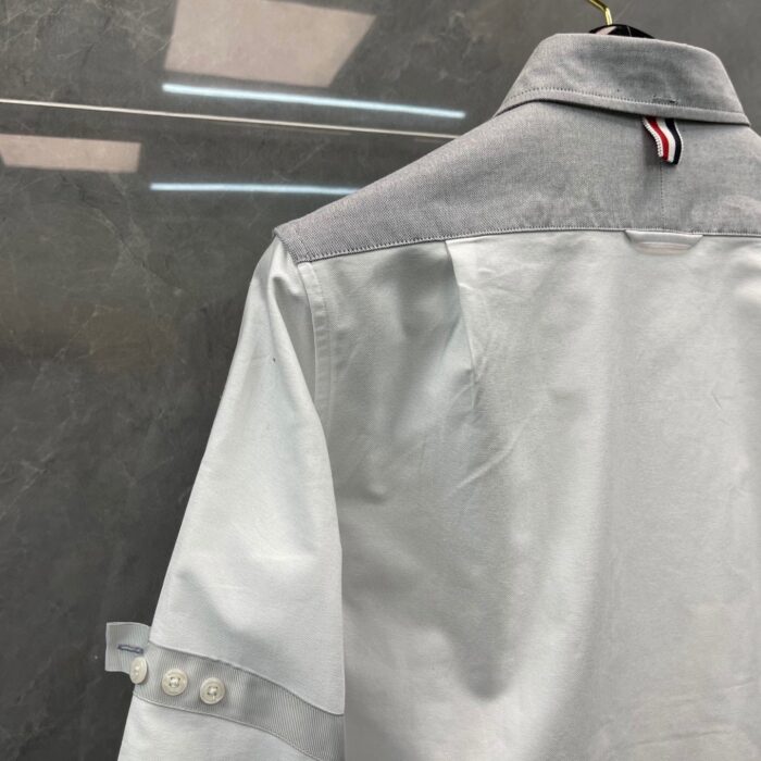 Camicia moderna con colletto grigio, dettagli eleganti e manicherollar in stile casual chic.