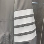 Cappotto moderno grigio con strisce bianche eleganti e lavorazione di alta qualità.