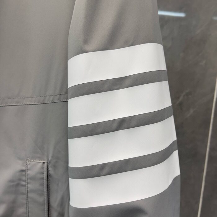 Cappotto moderno grigio con strisce bianche eleganti e lavorazione di alta qualità.