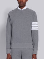 Felpa grigia moderna con dettagli a righe e layering classico, stile athleisure contemporaneo.
