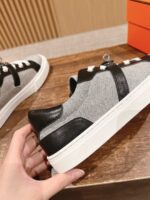 Sneaker moderna grigia con dettagli neri, su suola bianca, stile casual e raffinato.