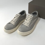 Sneakers grigie moderne con suola crema, stile elegante, materiali di qualità, perfette per ogni occasione.