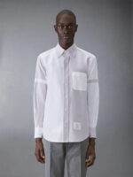 Uomo elegante con camicia bianca e pantaloni grigi, stile moderno e sofisticato.