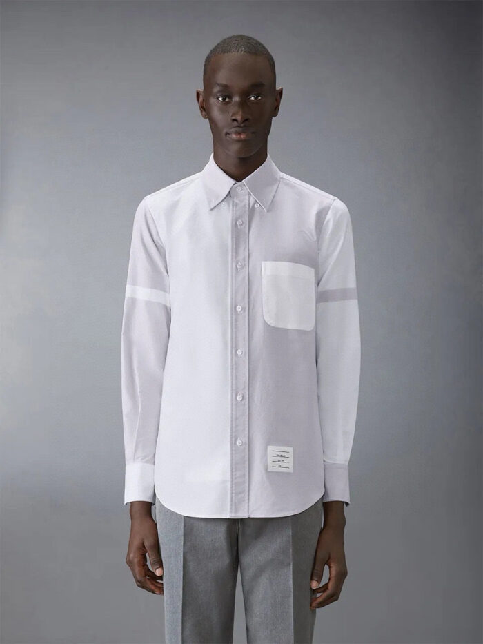 Uomo elegante con camicia bianca e pantaloni grigi, stile moderno e sofisticato.