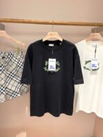Display di abbigliamento casual con T-shirt graphic e gonna a quadri su mensola in legno.
