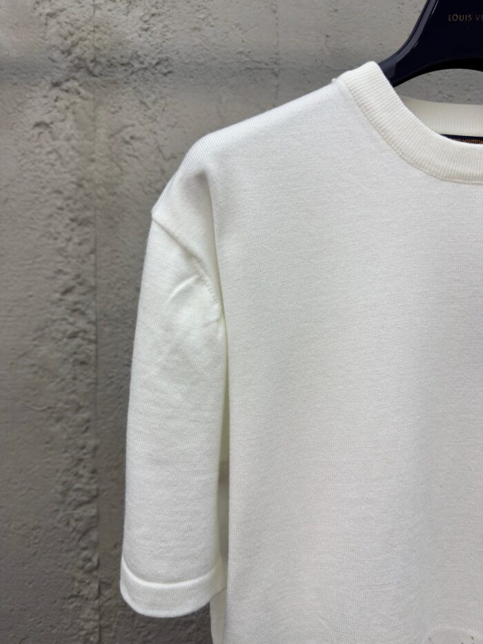 Maglietta bianca minimalista su sfondo industriale, ideale per uno stile casual e versatile.