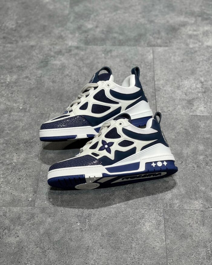 Scarpe sneakers moderne navy e bianco con emblema floreale, stile urbano e versatile.