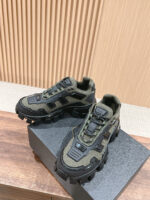 Sneakers urbane e outdoor verde oliva e nere, con suola robusta e dettagli geometrici moderni.