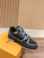 Sneaker nera moderna con dettagli grigi su scatola arancione, stile casual e fashion.