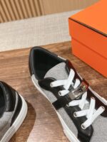 Sneaker elegante nero e grigio con dettaglio metallic, stile moderno e versatilità fashion.
