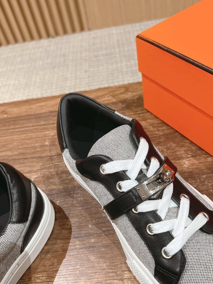 Sneaker elegante nero e grigio con dettaglio metallic, stile moderno e versatilità fashion.
