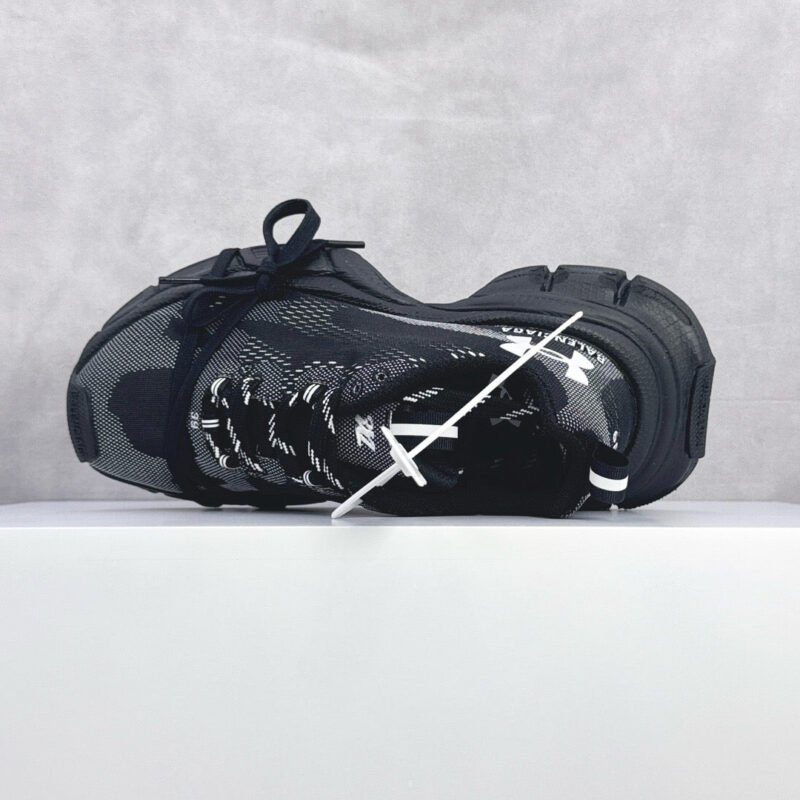 Sneaker nera moderna con suola traspirante, dettagli lucidi e stile urbano sportivo.