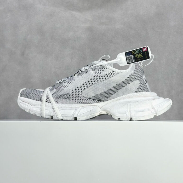 Sneaker bianca e grigia leggera con design moderno, suola chunky e dettaglio colorato allegro.