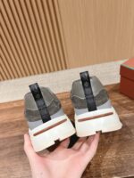 Sneakers moderne con tomaia grigia, dettaglio nero e suola bianca con inserto marrone.