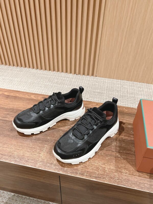 Scarpe sneakers nere e bianche moderne, stile sportivo, look urbano, su superficie di legno.