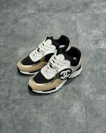 Sneakers moderne in nero e beige, stile sportivo e comfort per look casual e alla moda.