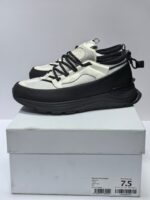 Sneakers moderne bianche e nere con suola elevata e design sportivo, ideali per stile e performance.