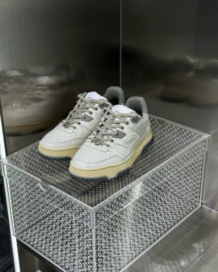 Scarpe sportive eleganti in vetrina minimalista con dettagli in mesh e materiali sintetici.
