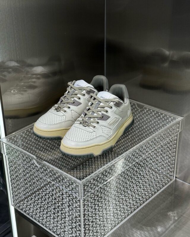 Scarpe sportive eleganti in vetrina minimalista con dettagli in mesh e materiali sintetici.