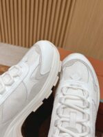 Sneakers bianche moderne con dettagli riflettenti, ideali per stile urbano e massimo comfort quotidiano.